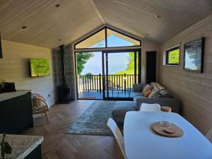 a living room with a couch and a table at Briarfield Farm Stays - Coillte Cabin in Glenarm