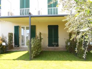 a house with green shutters and a yard at Albergo Blueline in Tellaro