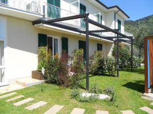 a white building with a balcony and a yard at Albergo Blueline in Tellaro