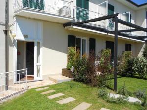 a white house with a balcony and a yard at Albergo Blueline in Tellaro