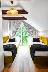 two beds in a room with a large window at Zdrojowe Zacisze in Iwonicz-Zdrój +36 photos