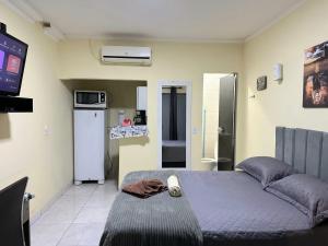 a bedroom with a bed and a tv in a room at Capim de Ouro Flats Mobiliados in Palmas