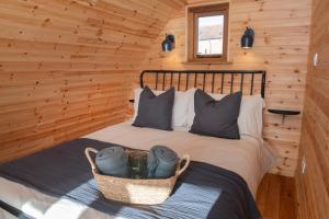 ein Schlafzimmer mit einem Bett in einer Blockhütte in der Unterkunft Deluxe Scandi Glamping Pod - Comfort in Ebberston