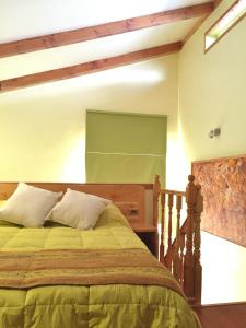 een slaapkamer met een bed met een groene sprei bij Tribu Malen Apartamentos in Temuco