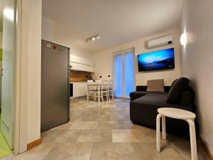 a living room with a black couch and a kitchen at Nido del Golf in Albisola Superiore