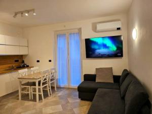 a living room with a couch and a television on a wall at Nido del Golf in Albisola Superiore +19 photos
