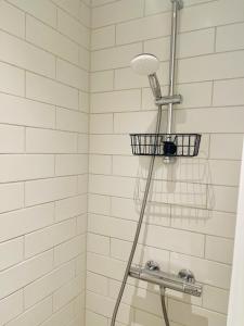 a shower with a shower head and a basket at Nuuk Stay in Nuuk