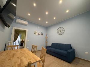 a living room with a blue couch and a table at Don Mimì Casa Vacanza in Torre del Greco
