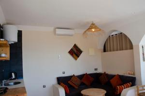 a living room with a couch and a table at SurfAppart Morocco in Tamraght Ouzdar