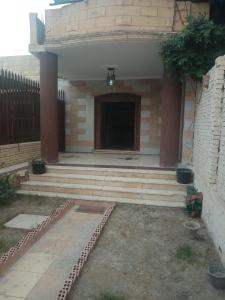 a building with a porch with a door and a fence at PYRAMIDS Villa T Medetion Camping in Banī Ghālib