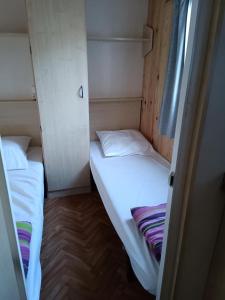 una piccola camera con due letti di Camping Les Embruns N2 a Le Grau-dʼAgde