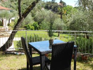 a table with two chairs and a potted plant on it at Albergo Blueline in Tellaro