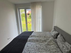 a bedroom with a bed and a large window at Appartement Löwenzahn in Spangenberg