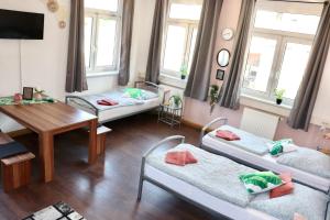 Habitación con 3 camas y mesa. en Sei hier Gast - Unterkunft Zimmer Klosterhof Aschersleben, en Aschersleben
