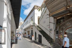 Un groupe de personnes marchant dans une rue avec des bâtiments dans l'établissement Casina Caprese, à Capri