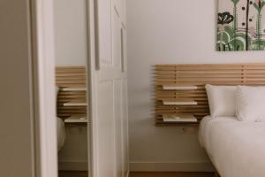 ein Schlafzimmer mit einem Bett und einem hölzernen Kopfteil in der Unterkunft Apartamento junto al Recinto Ferial con garaje y aire acondicionado in Albacete