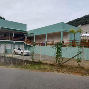 a building with a car parked in front of it at Suites Vitasha - Ubatumirim in Ubatuba