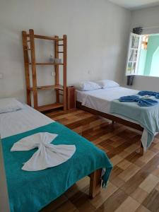 a bedroom with two beds with towels on them at Suites Vitasha - Ubatumirim in Ubatuba