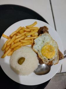 a plate of food with eggs and french fries at Suites Vitasha - Ubatumirim in Ubatuba