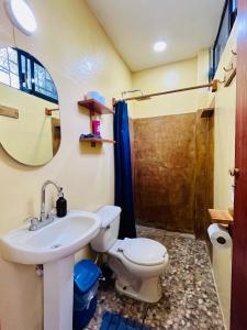 a bathroom with a sink and a toilet and a shower at Casa Shula 1 AC Starlink 2min walk to the beach in Brisas de Zicatela