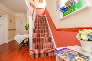 a staircase in a home with orange walls at Harris Guest Accommodation in Oxford