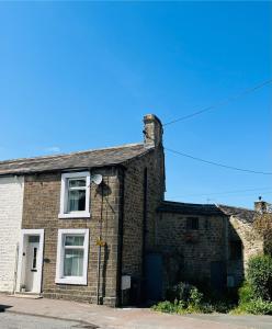 ein altes Backsteinhaus mit einem weißen Fenster in der Unterkunft Katys Cottage, Barnoldswick in Barnoldswick + 9 Fotos