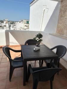 Una mesa y sillas negras con una planta en un balcón. en C'era una volta, en Martina Franca 9 fotos más