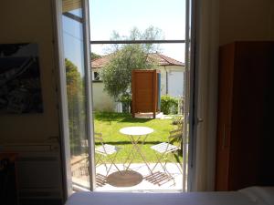 a bedroom with a door open to a patio with a table at Albergo Blueline in Tellaro