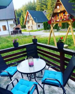 un patio con tavolo, sedie e una casa di Villa KAVAZ Vlašić a Gornja Šišava