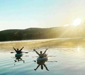 two people in kayaks in the water on a lake at Lakefront Home-Stunning Views-Hot Tub, 3100 sqft! in Wakefield