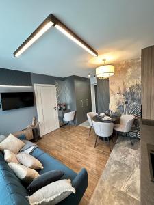 un soggiorno con un divano blu e un tavolo di Apartamenty Kielce-CARMEL, Rynek, Sienkiewicza, centrum, fv, targi a Kielce Altre 60 foto