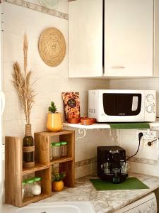 a kitchen with a microwave and a coffee maker on a counter at Cosy calme appartement à la Marsa in La Marsa