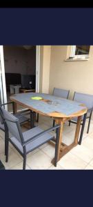 a wooden table with chairs around it in a room at appartement bords de Mer in Santa-Lucia-di-Moriani +3 photos