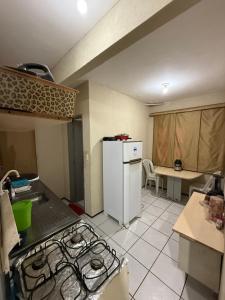 a kitchen with a stove and a white refrigerator at Apartamento mobiliado com dois quartos para locação fixo e mensal in Fortaleza +3 photos