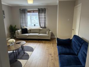 een woonkamer met een bank en een tafel bij 3 BDR House At Caledonia Luxe Stays Short Lets & Serviced Accommodation Livingston in Livingston
