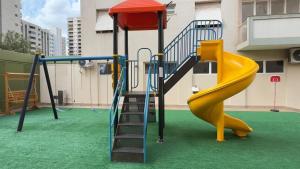 a playground with a slide on a green floor at Edifício Aquarius in Ribeirão Preto