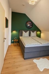 a bedroom with a bed and a green wall at Dimi Living Oberhausen & mit Küche in Oberhausen