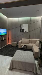 un salon avec un canapé et une télévision à écran plat dans l'établissement شقه انيقة بغرفه وصاله مدخل خاص, à ‘Aryam