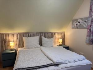 ein Schlafzimmer mit einem Bett mit weißen Laken und Kissen in der Unterkunft Apartment in Kellerwald near Edersee Lake in Frankenau