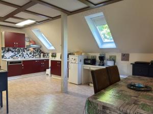 eine Küche mit einem Tisch und eine Küche mit Oberlichtern in der Unterkunft Apartment in Kellerwald near Edersee Lake in Frankenau