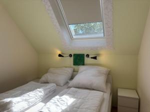zwei Betten in einem kleinen Zimmer mit Fenster in der Unterkunft Apartment in Kellerwald near Edersee Lake in Frankenau