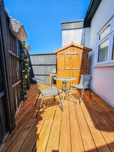 a patio with a table and chairs on a wooden deck at Cleave House - Modern 3 Bed and 2 Bath House - Sleeps 6 - Contractors Corporate and Family Friendly in Farnborough
