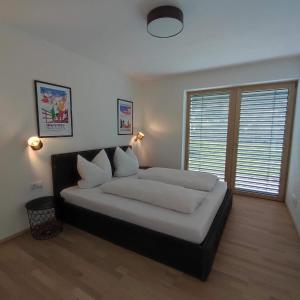a bedroom with a bed with white sheets and pillows at Apart Loris in Hart im Zillertal