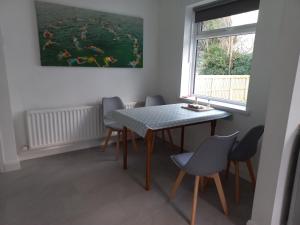 ein Esszimmer mit Tisch und Stühlen und einem Gemälde in der Unterkunft Mourne Hikers' Cottage in Newcastle