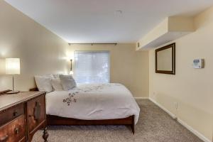 a bedroom with a bed and a dresser and a window at 1 Mi to UMD Convenient and Cozy Condo with Patio! in Berwyn Heights