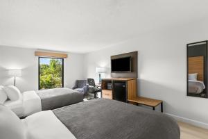 a hotel room with two beds and a flat screen tv at Quality Inn Tallapoosa in Tallapoosa