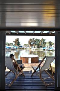 a person sitting in two chairs on a dock at Paraiso Flotante in San Fernando