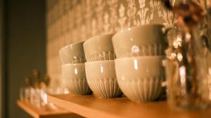 a row of white cups sitting on a shelf at Sov Lodge in Vågåmo +44 photos