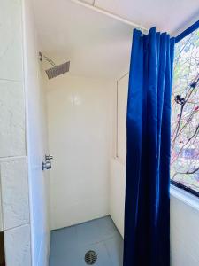 a shower with a blue curtain in a bathroom at Casa Shula 3 AC Starlink 2min walk to the beach in Brisas de Zicatela