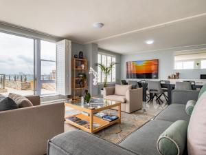 a living room with a couch and a table at Lagoon Shoreline Penthouse in Cape Town